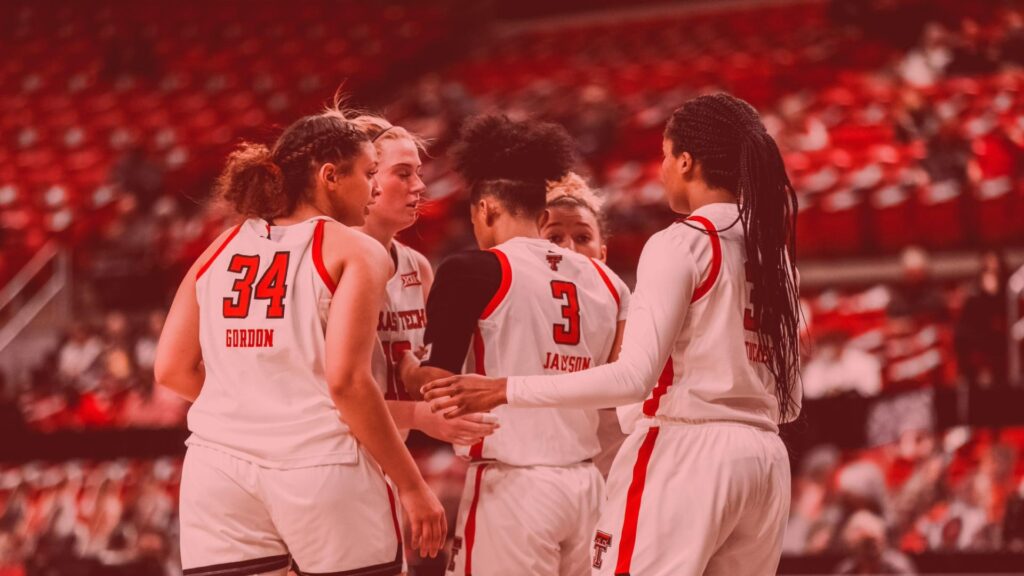 Lady Raiders huddle together after a play in a basketball match-up