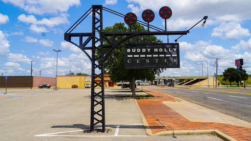 photo of the buddy holly center sign with downtown lubbock street in the background